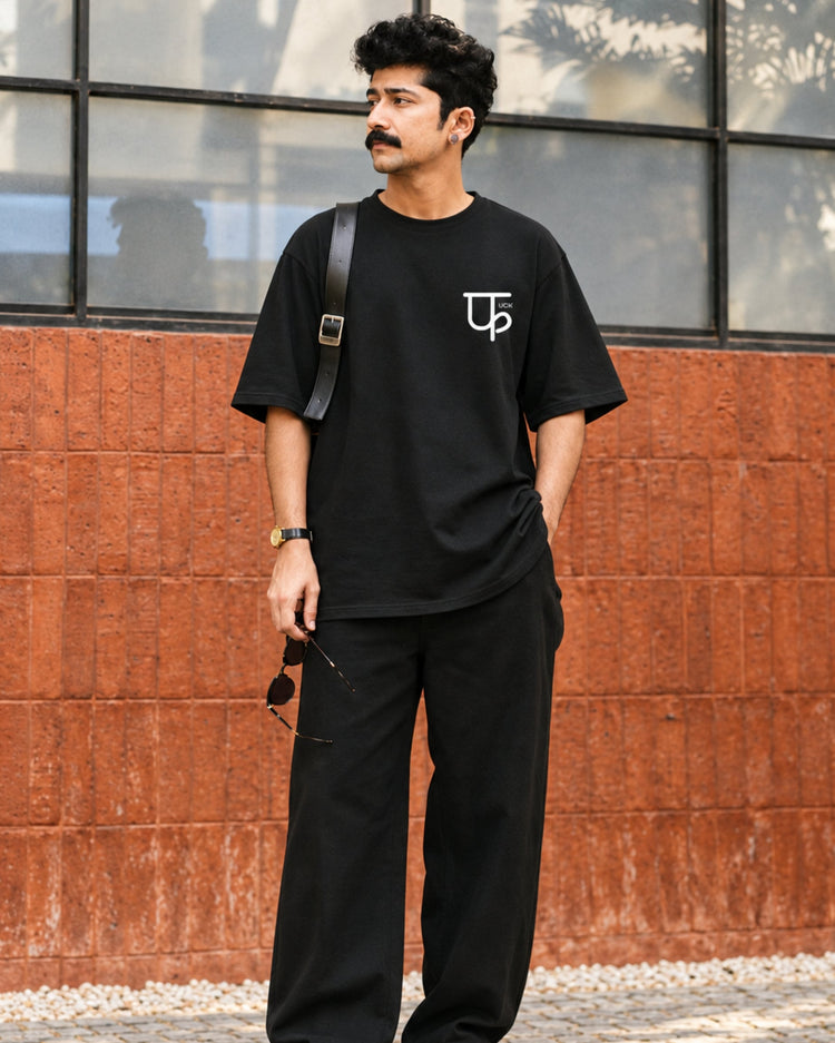 Minimalistic फuck black tee styled with black trousers, full length