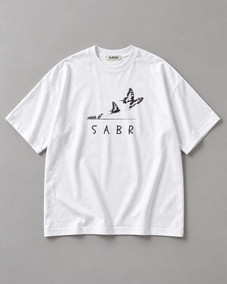 SABR white oversized tee laid flat on a grey background