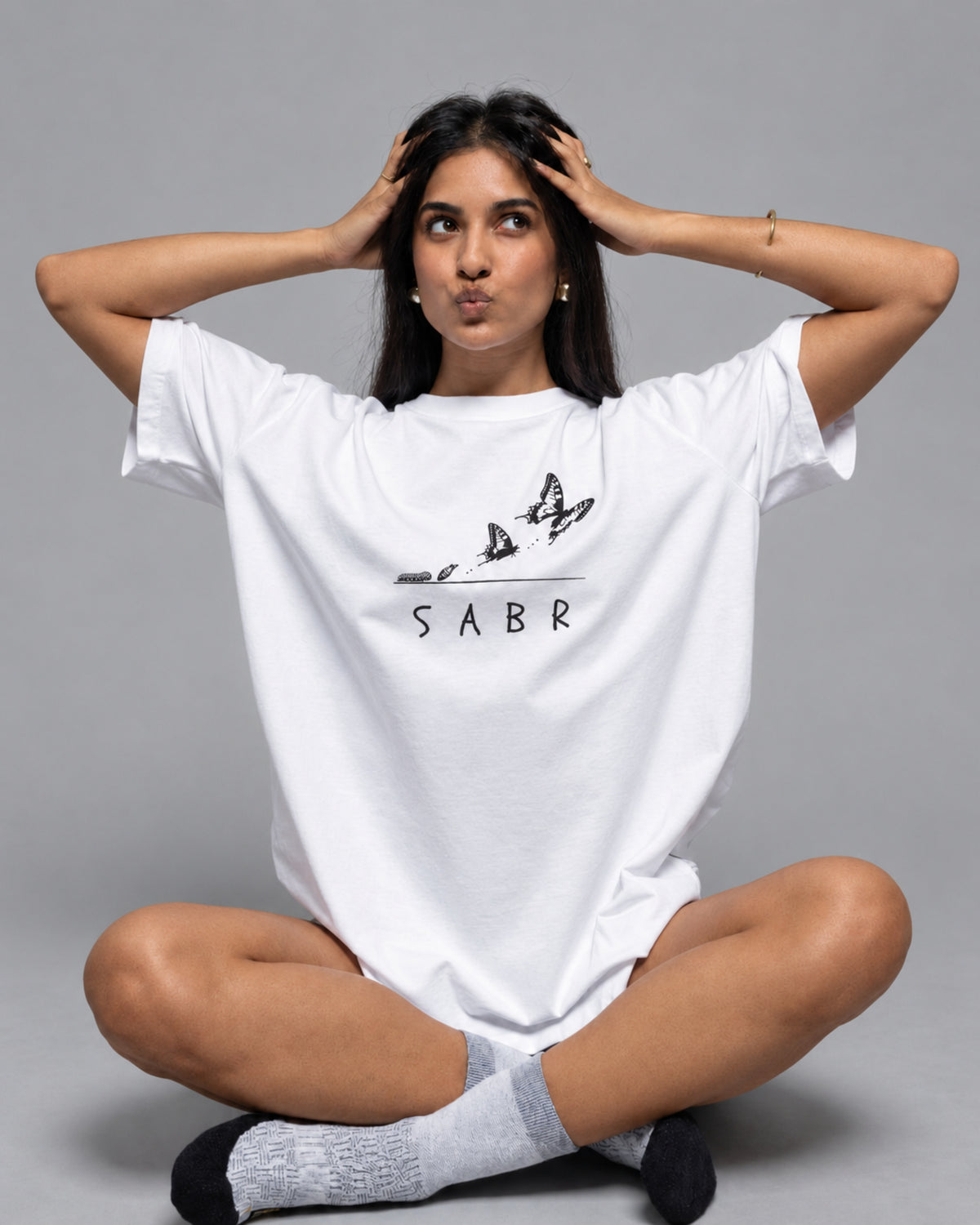 SABR white oversized tee with a butterfly print, worn by a model