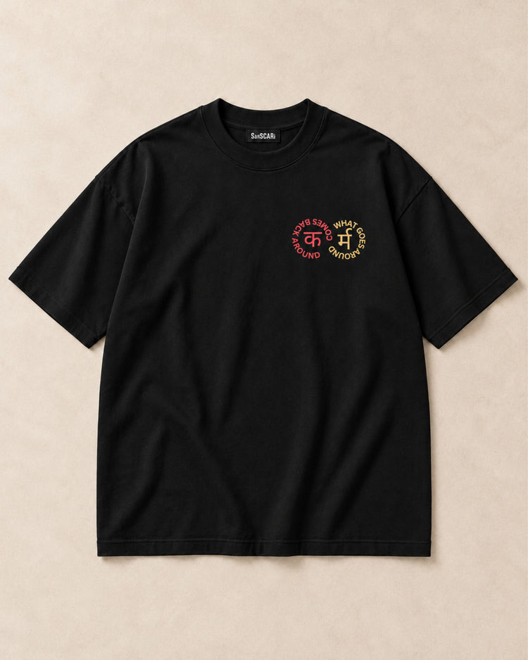 Karma black oversized tee, full front on a stone background