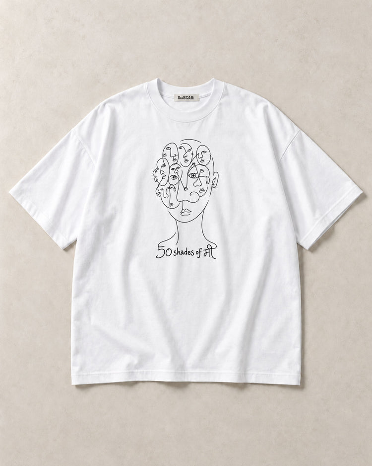 50 Shades of मी white oversized tee laid flat on a stone background