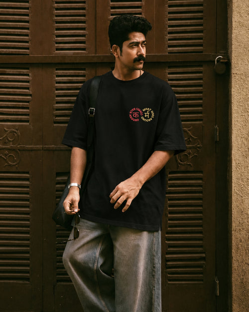 Karma black tee styled with grey trousers, full length