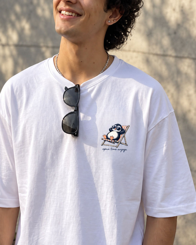 Apna Time Aayega white oversized tee with a small penguin print on the chest