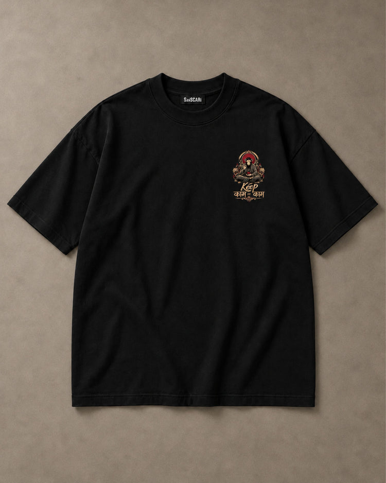 Keep काम se काम black oversized tee, full front on a stone background