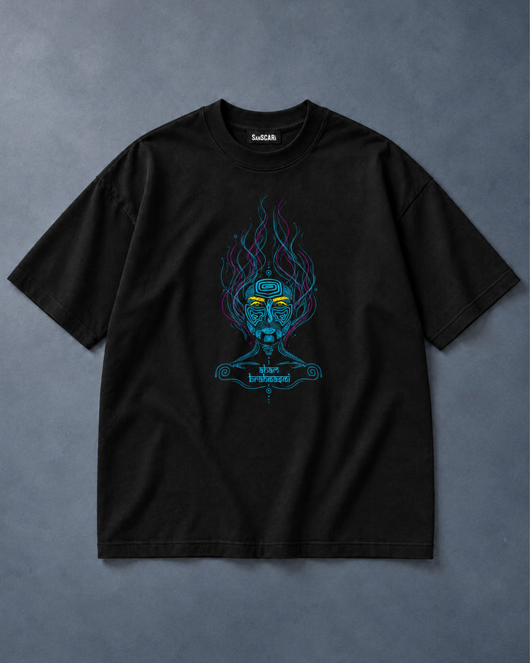 Aham Brahmasmi black oversized tee laid flat on a grey background
